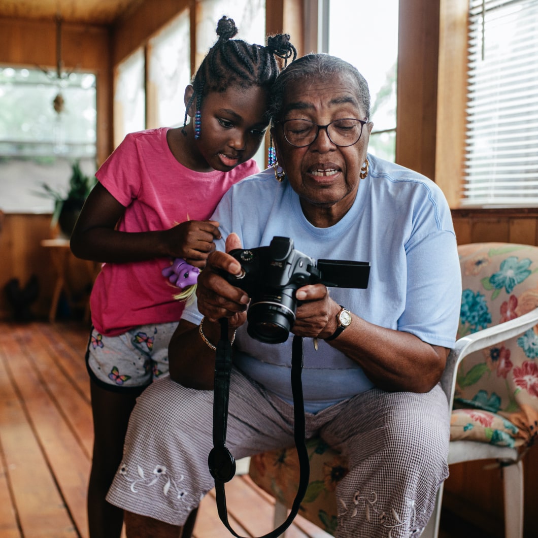 一名女孩和她的祖母正在看数码相机上的照片