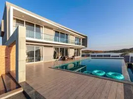 StayVista's Bellisimo Panorama - Lakeside Oasis with Infinity Pool, Modern Interiors, Open-to-Sky Bathtub, and Lush Green Lawn