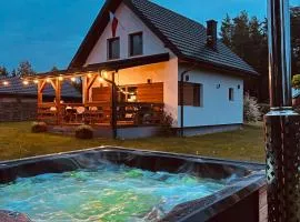 Domek z kominkiem nad jeziorem z jacuzzi ogrodowym