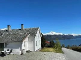 Stort hus med tømmervegger og fjordutsikt