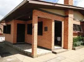 CASA COMPLETA E CENTRAL, 4 Qtos, Wi-Fi, 130m quadrados, 4 Camas Casal, 2 Banheiros 9 Pessoas, Vasto Quintal e Área Verde, Varanda nos Fundos e Área Frontal, Garagem Coberta, Estacionamento Interno para 2 Carros, Churrasqueira, Fogão a Lenha