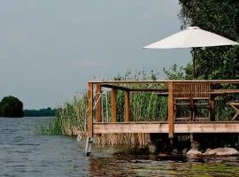 Lakefront house with beach, jetty, and rowing boat