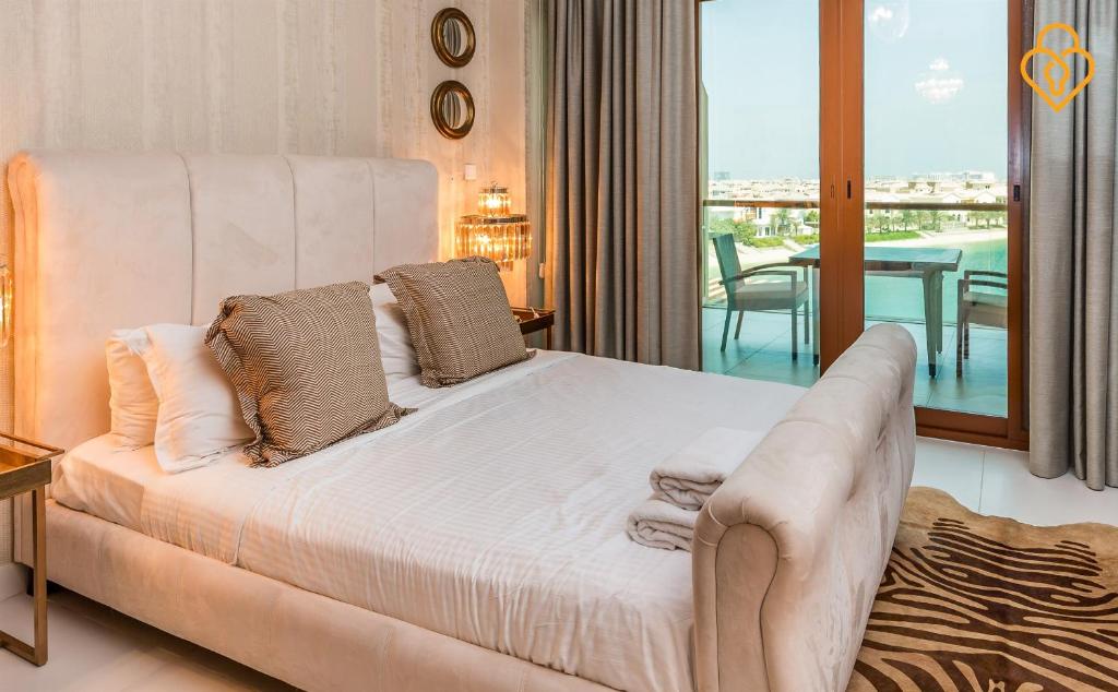 迪拜吉斯普利斯度假屋 - 东棕榈景的一间带一张白色大床的卧室和一个阳台