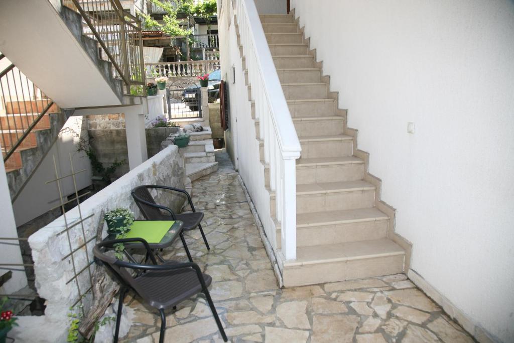 蒂瓦特Apartments Oasis的庭院设有桌椅和楼梯。