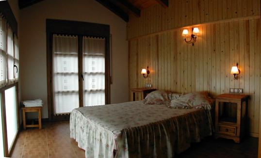 布罗托加布里酒店的一间卧室设有床、两张桌子和两个窗户。