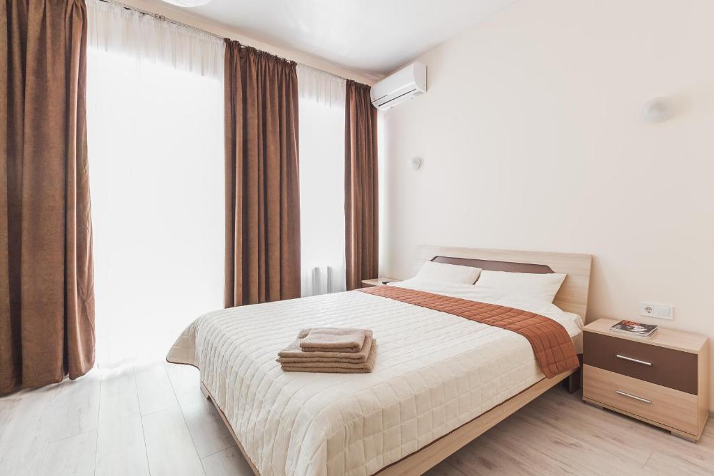 敖德萨Apartments near Deribasovskaya的一间卧室配有一张带棕色窗帘的大床