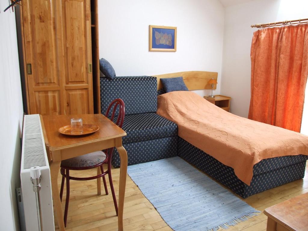 佩奇戴安娜酒店的一间小卧室,配有一张床铺、一张桌子和一张书桌