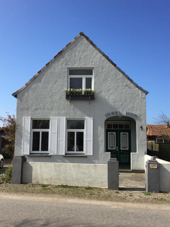 彼得多夫奥费马"Insel-Hus" Fehmarn Petersdorf的灰色的房子,有绿色的门和窗户