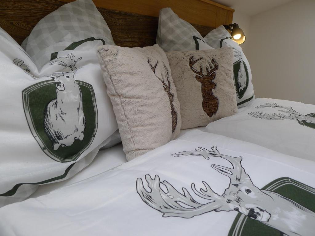 阿布特瑙达奇斯坦糟贝尔公寓 的床上配有枕头,上面有鹿
