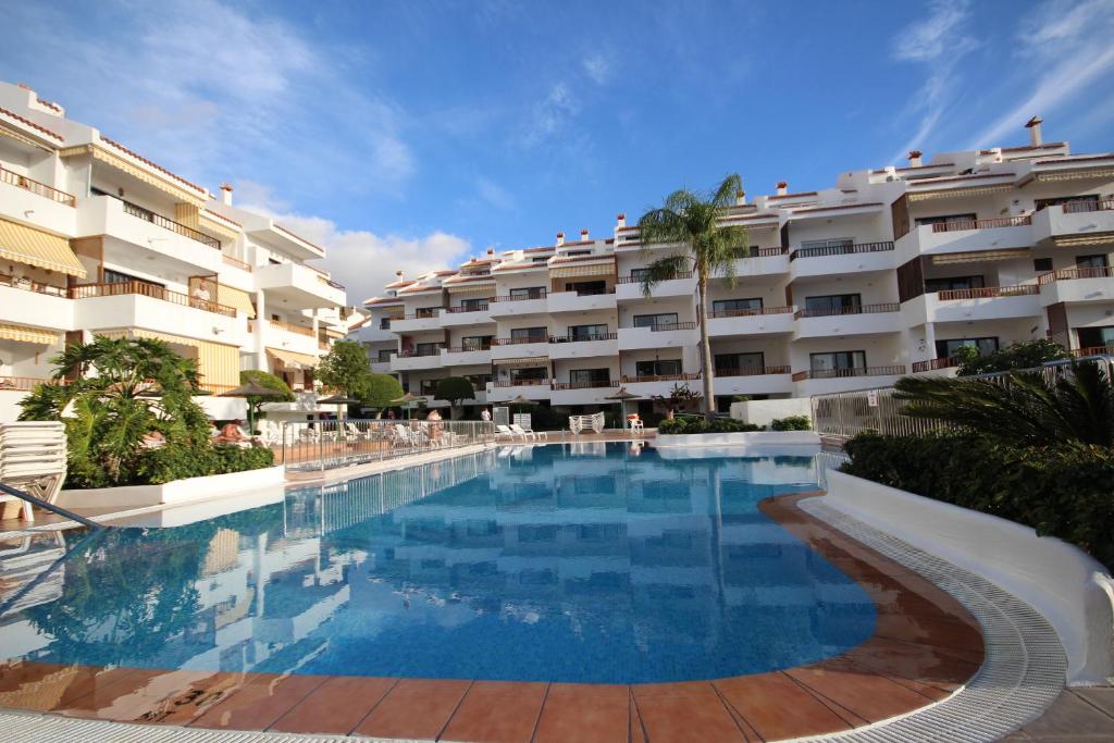 洛斯克里斯蒂亚诺斯Apartment Sur Sunrises, Los Cristianos的酒店前方的大型游泳池
