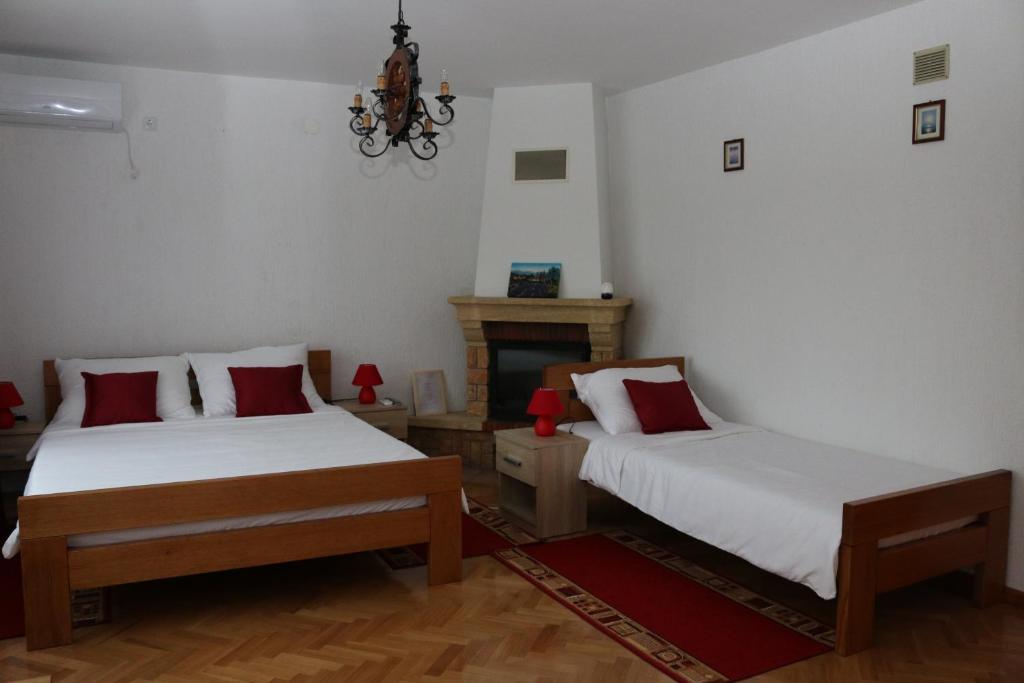卡尔洛瓦茨House Bogović的一间卧室设有两张床和一个壁炉