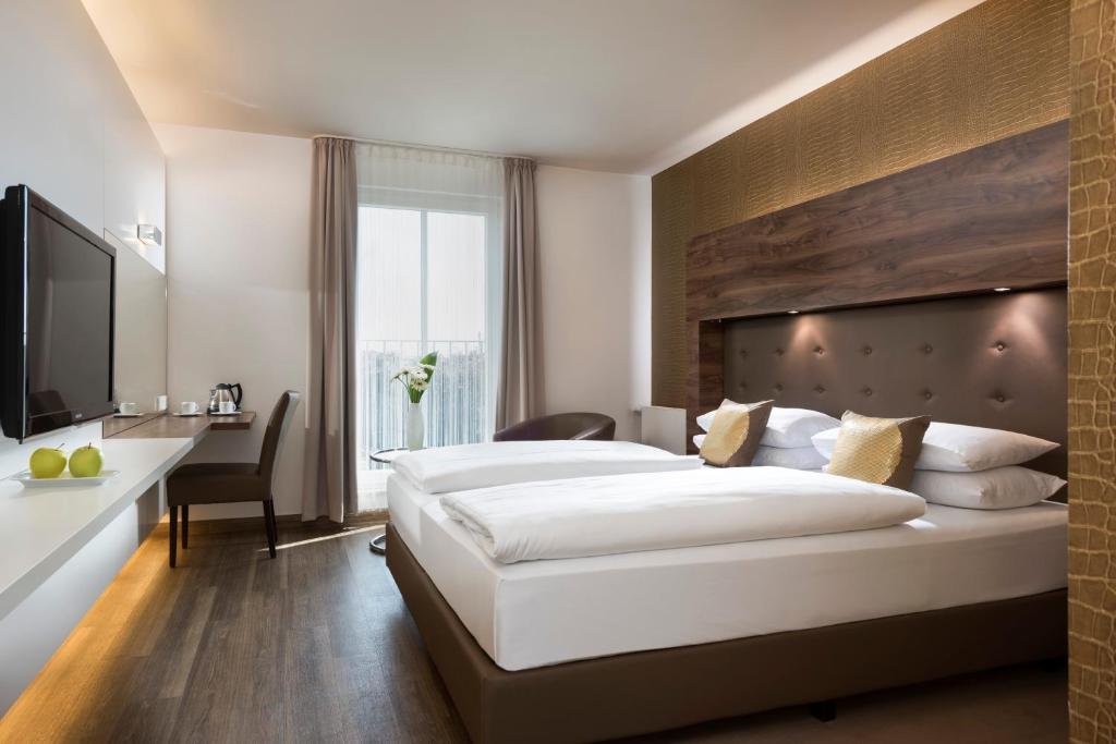 杜伊斯堡孔蒂杜伊斯堡酒店-索拉酒店的合作伙伴的酒店客房设有一张大床和一张书桌。