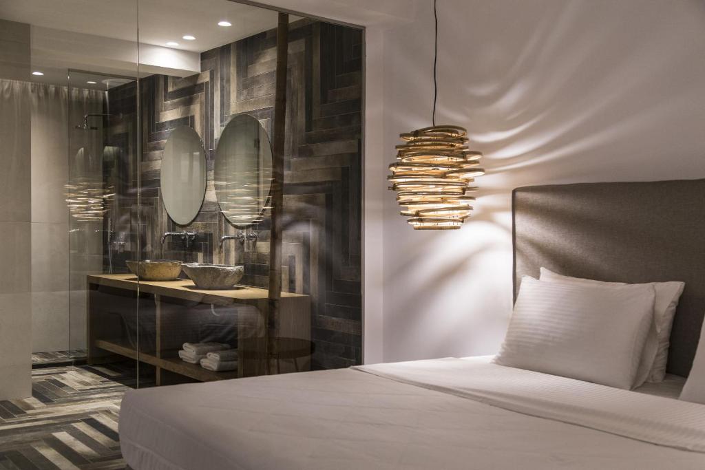 法蒂亚Ftelia Bay Boutique Hotel的卧室配有一张床,墙上有两面镜子