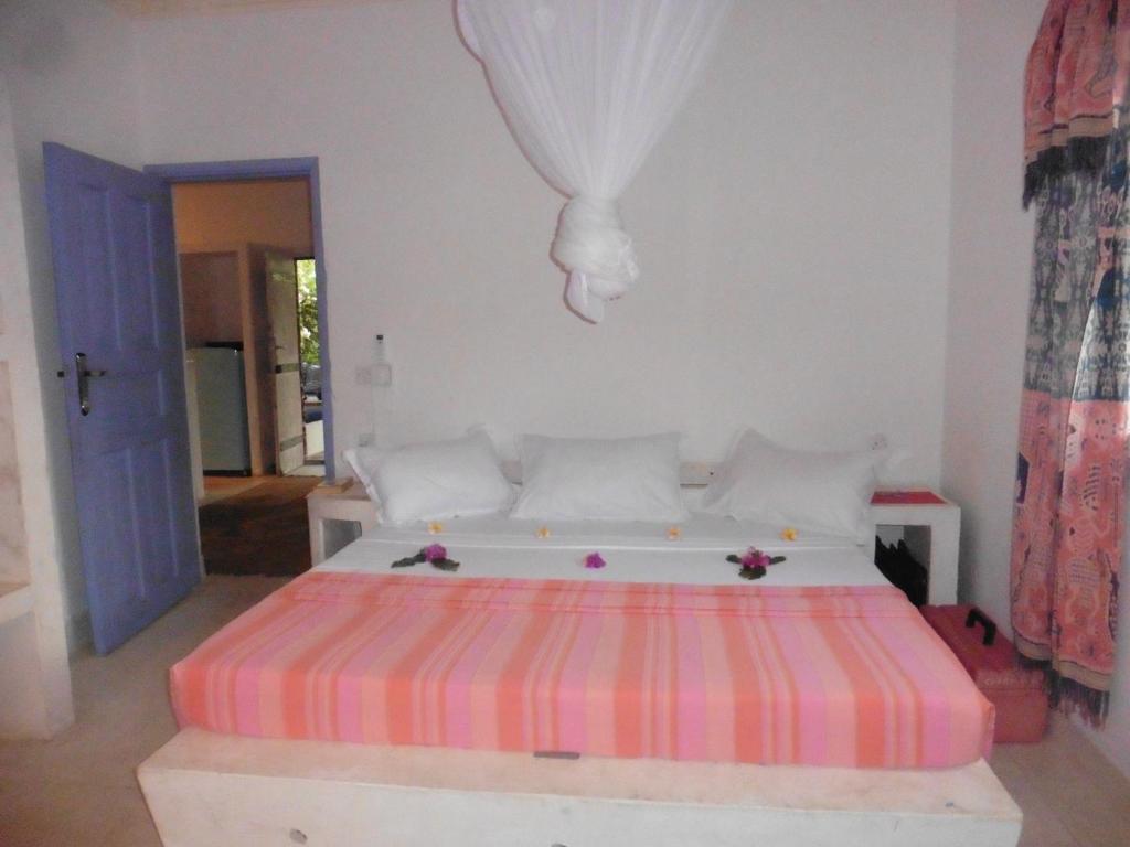 马林迪Downtown Malindi Apartment的一间卧室配有一张带条纹床垫的床