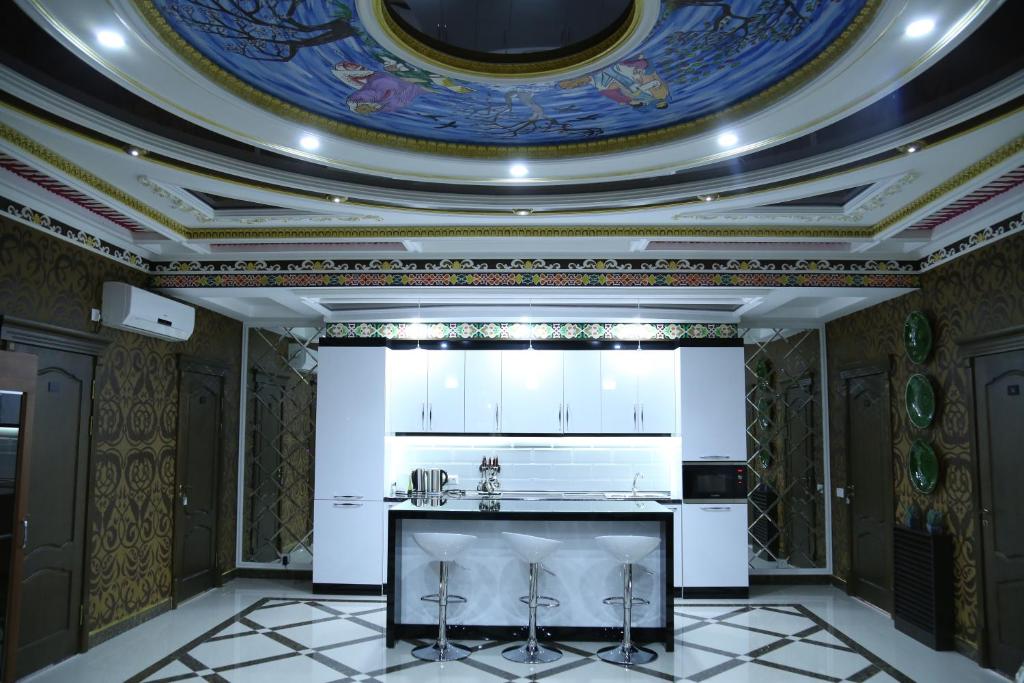 杜尚别Sunrise Apartments的厨房设有格子天花板和白色橱柜。