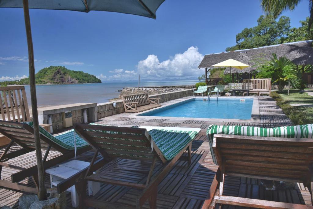 Ambondrona依兰酒店的一个带游泳池、椅子和遮阳伞的度假村