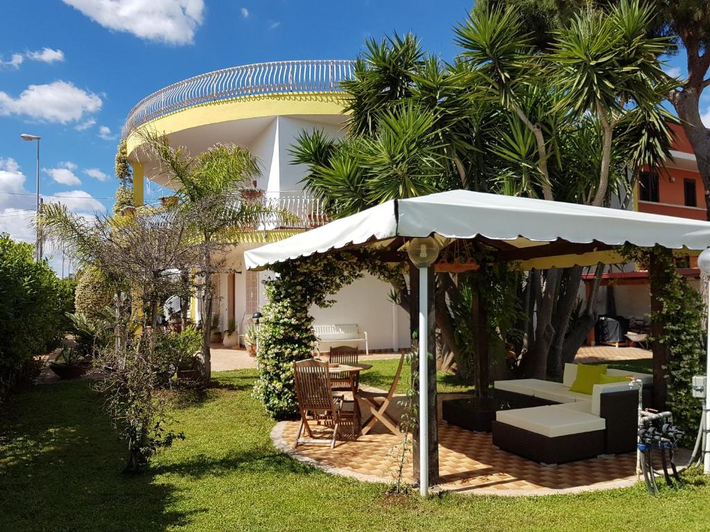 切萨雷奥港B&B Simonetta的庭院配有遮阳伞和桌椅。