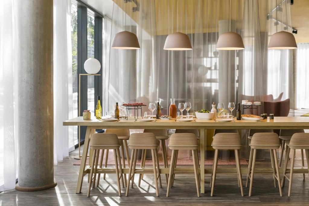 巴黎巴黎凡尔赛门奥科酒店的用餐室配有带凳子的大木桌