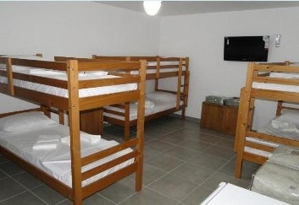 萨夸雷马Spazio Itauna Hostel的客房设有三张双层床和一台平面电视。