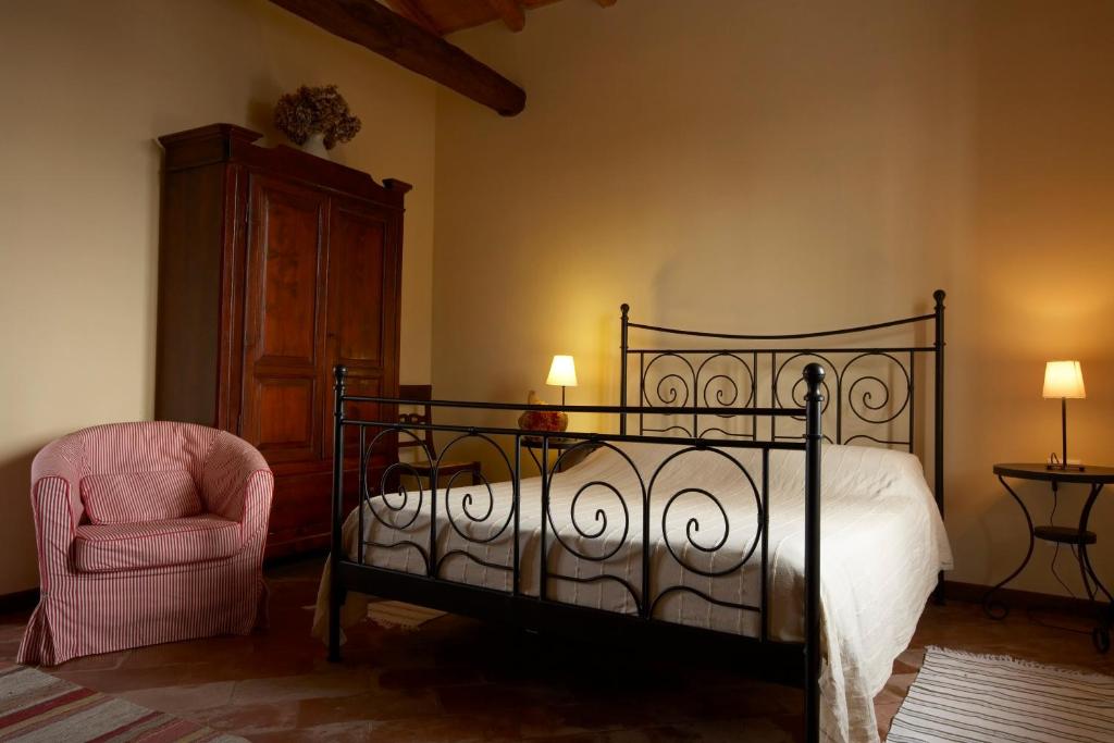 Cisliano奇斯利亚诺斯卡纳农家乐的一间卧室配有一张床和一把椅子