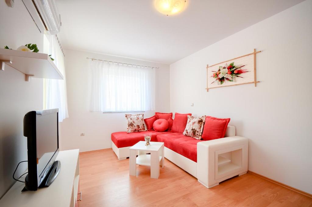 梅杜林Apartments Dario的客厅配有红色沙发和电视