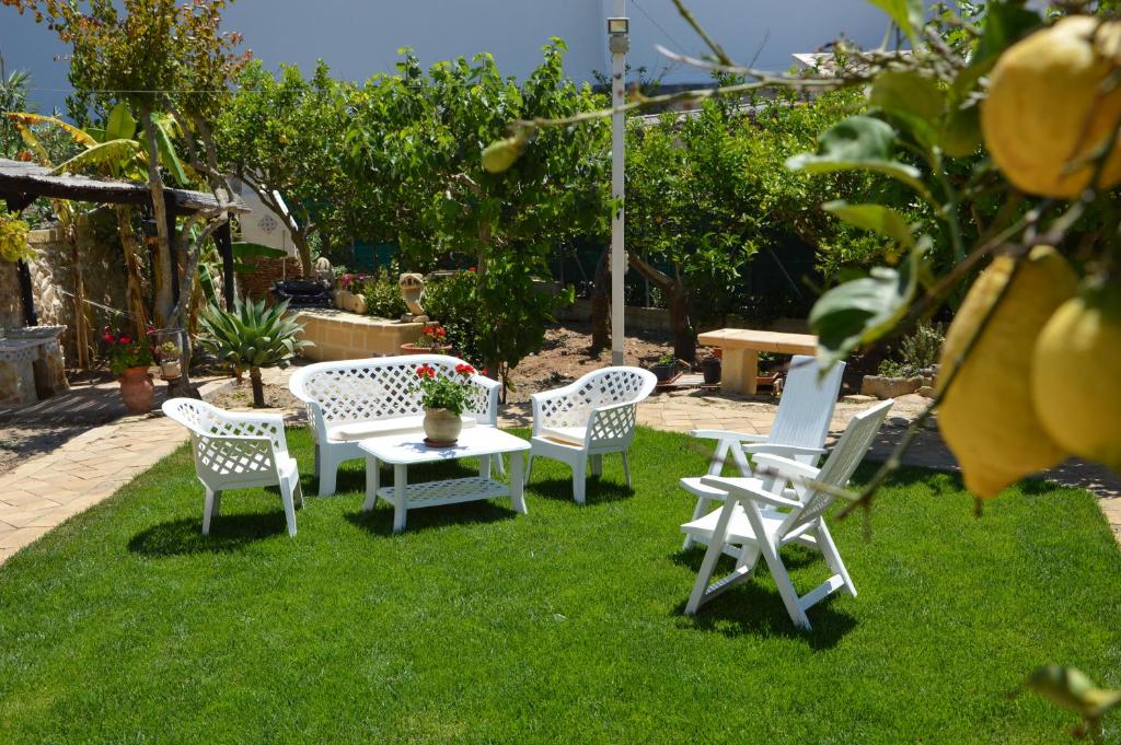 法维尼亚纳Guest House Al Giardino dei Limoni的一群白色的椅子和一张桌子在草地上