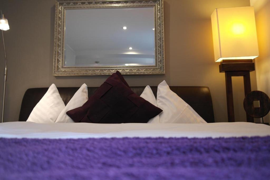 阿姆施泰滕勒什特弗雷德旅馆的一间卧室配有一张带紫色和白色枕头的床