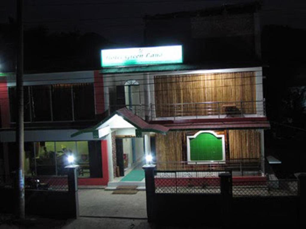 BāndarbanHotel Green Land的一座在晚上有绿色标志的建筑