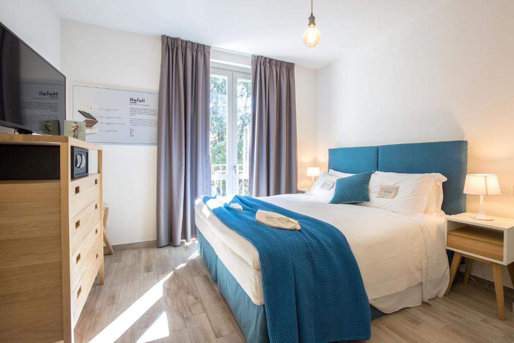 佛罗伦萨Coco Places Firenze, Centro Storico的一间卧室配有一张大床和蓝色床头板