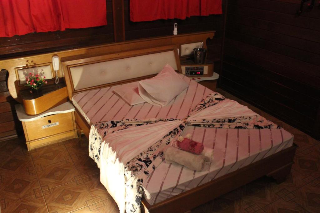 圣若泽杜斯坎普斯Motel Paradise (Adults only)的一间卧室配有一张带粉色和白色棉被的床