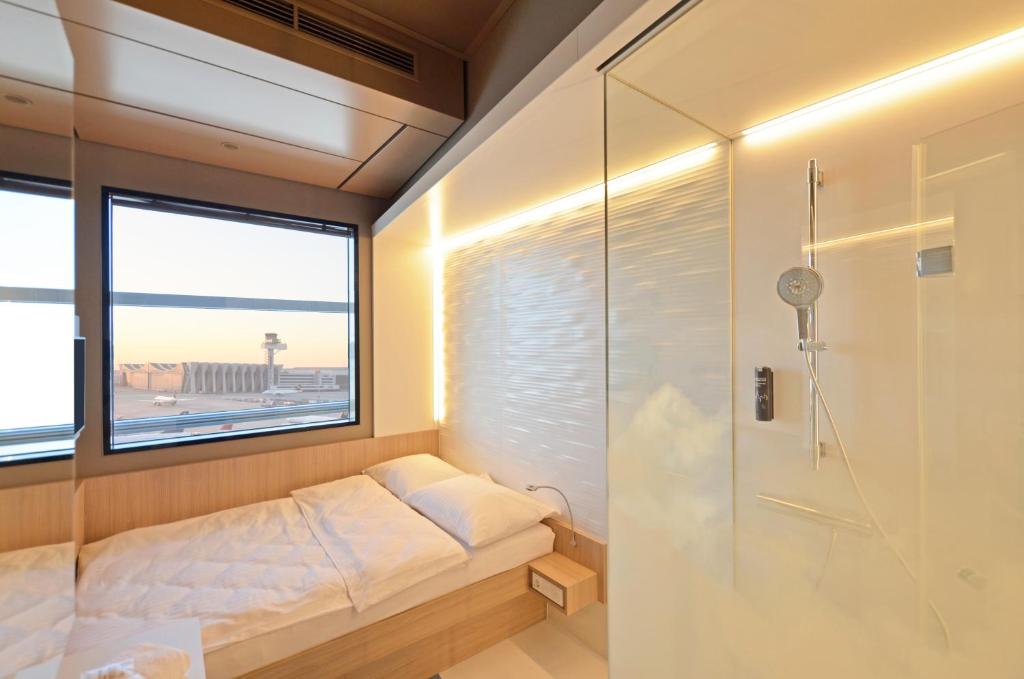 美因河畔法兰克福我的云端过境酒店 - 只允许乘坐国际航班的客人入住！的淋浴间设有床和窗户。