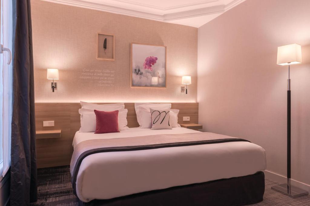 巴黎Magda Champs Elysées的酒店客房配有一张带枕头的大床