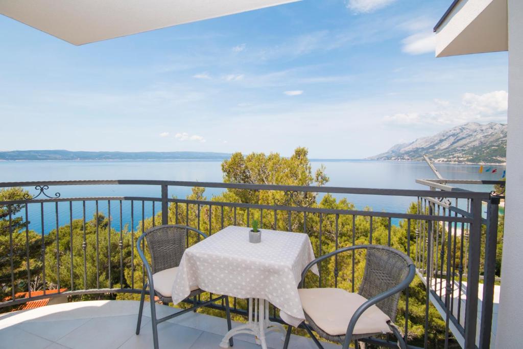 布雷拉Sea View Apartment Gin Brela的阳台配有桌椅,享有水景。