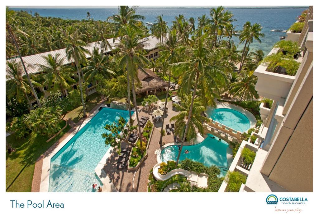 麦克坦康斯特白拉热带海滩度假村的享有度假村的空中景致,设有2个游泳池和棕榈树