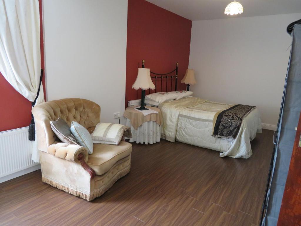 贝尔马利特Leam Cottage的一间卧室配有一张床、一张沙发和一把椅子
