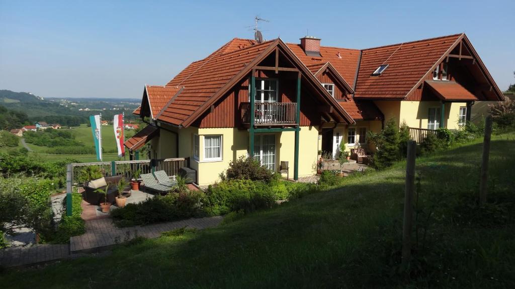 巴特格莱兴贝格Pension Dreiländerblick的山坡上一座红色屋顶的房子
