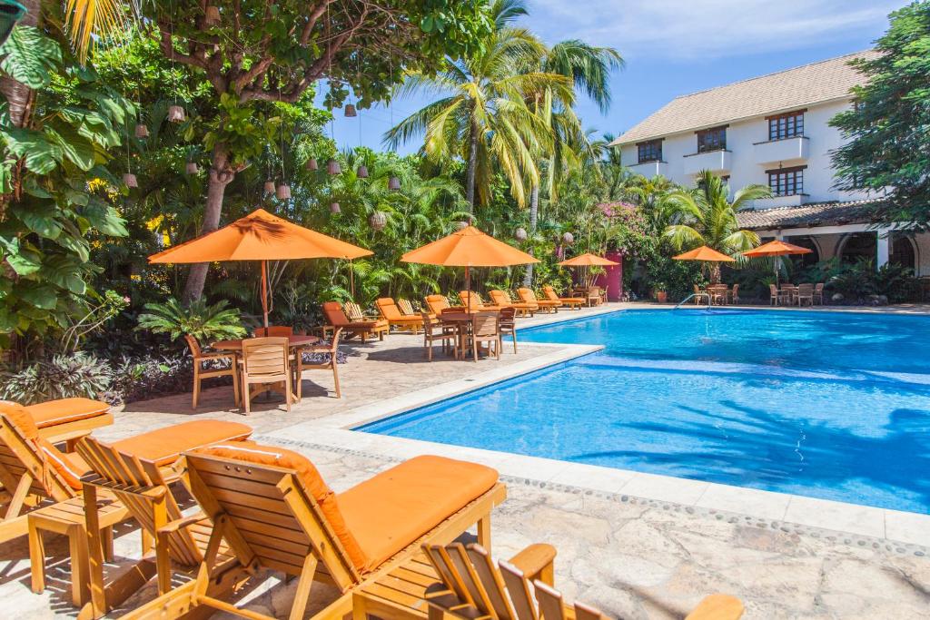 圣克鲁斯华特库布兰卡瓦图尔科别墅酒店的酒店旁的游泳池配有椅子和遮阳伞