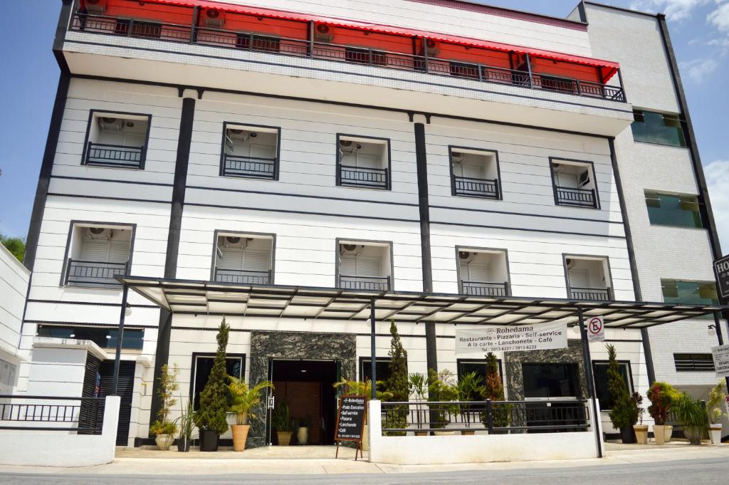 瓜拉廷格塔洛河大马酒店的一座白色的大建筑,有红色的屋顶