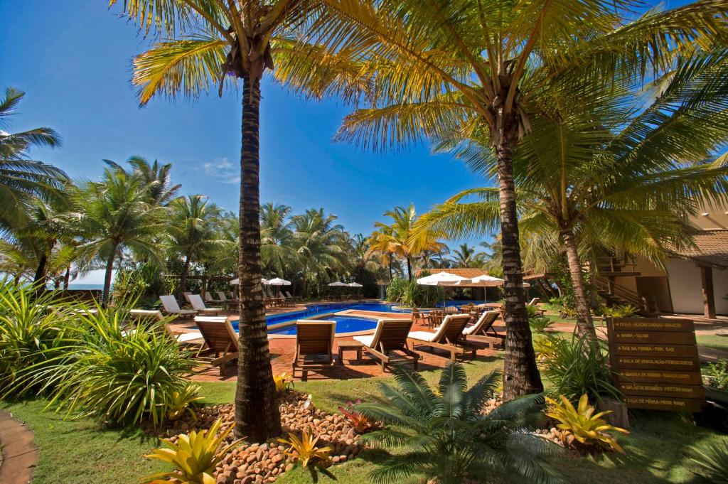 皮帕班奎坦戈酒店的一个带游泳池、椅子和棕榈树的度假村