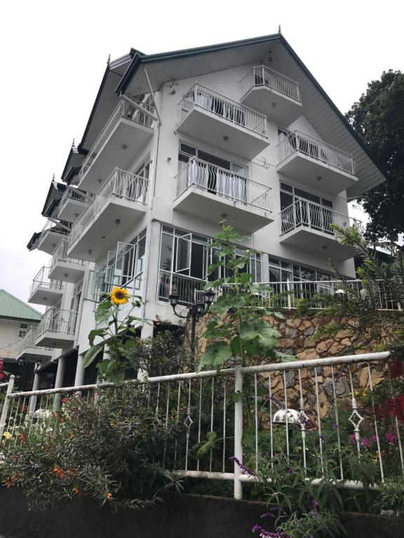 努沃勒埃利耶格雷戈里湖朦胧天堂住宿加早餐旅馆的带阳台和鲜花的白色公寓大楼