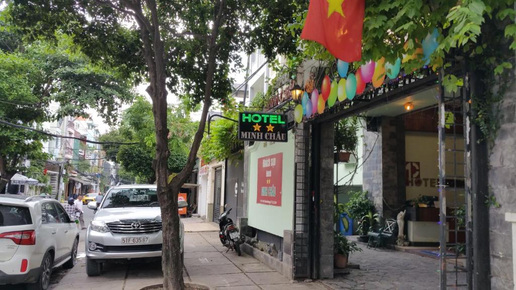 胡志明市Khách sạn Minh Châu - Hòa Hưng的街道旁人行道上的酒店标志