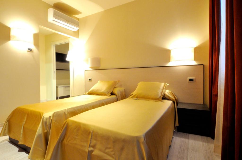特尔尼迪亚曼特罗索酒店的酒店客房带两张带黄床单的床