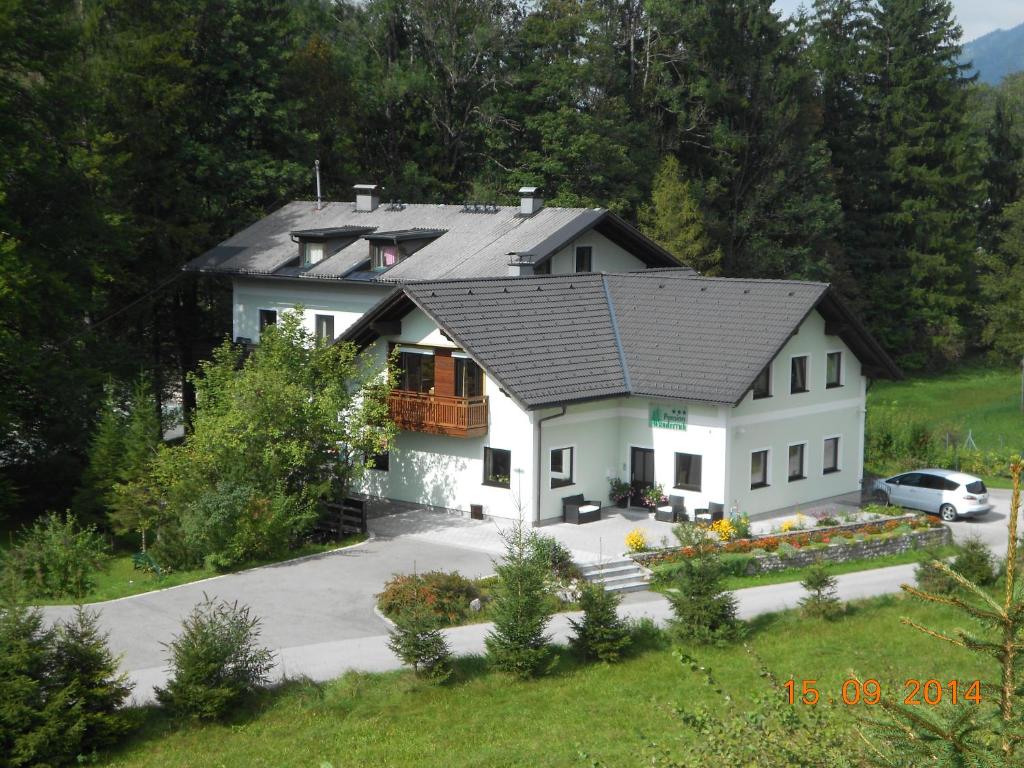 格吕瑙Pension Wanderruh的黑色屋顶的白色房子