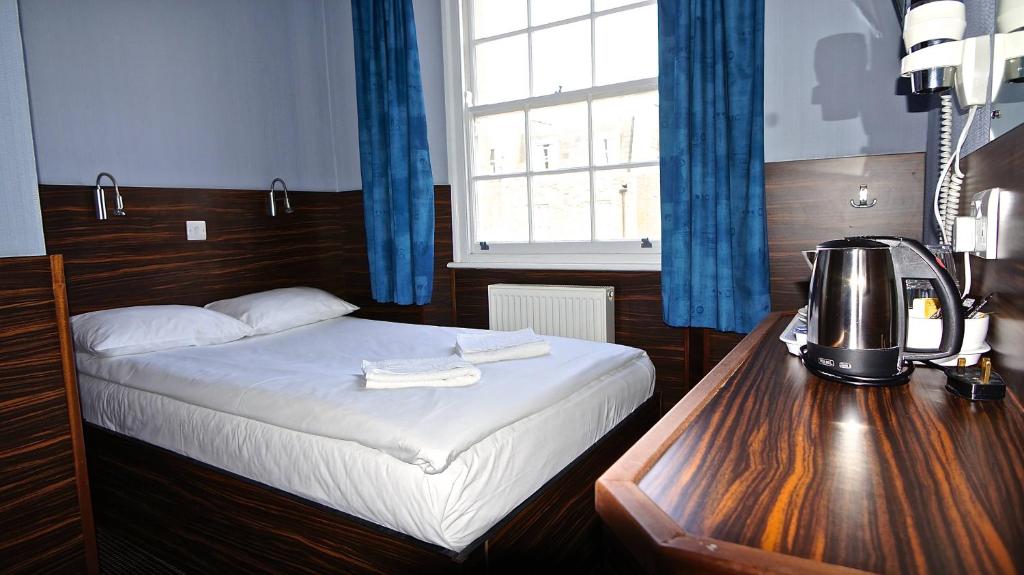 伦敦克莱斯特菲尔德酒店的一间卧室配有一张床和一张桌子及咖啡壶