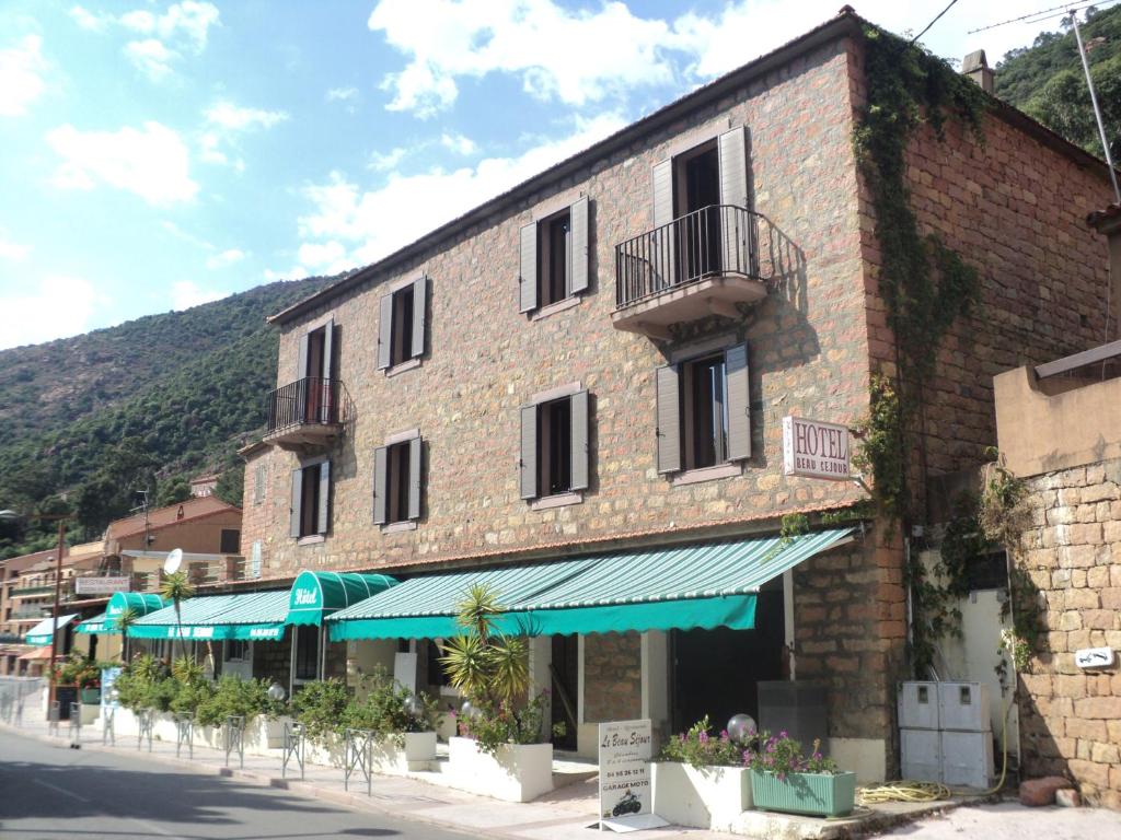 波尔图Hotel & Restaurant Le Beau Sejour的街道上一座大型砖砌建筑,设有阳台