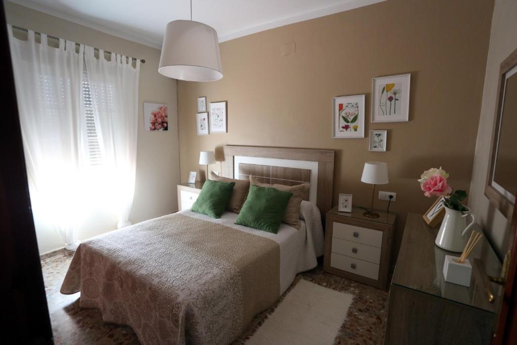 阿尔科斯-德拉弗龙特拉Apartamento Duque de Arcos的一间卧室配有一张带绿色枕头的床和一扇窗户