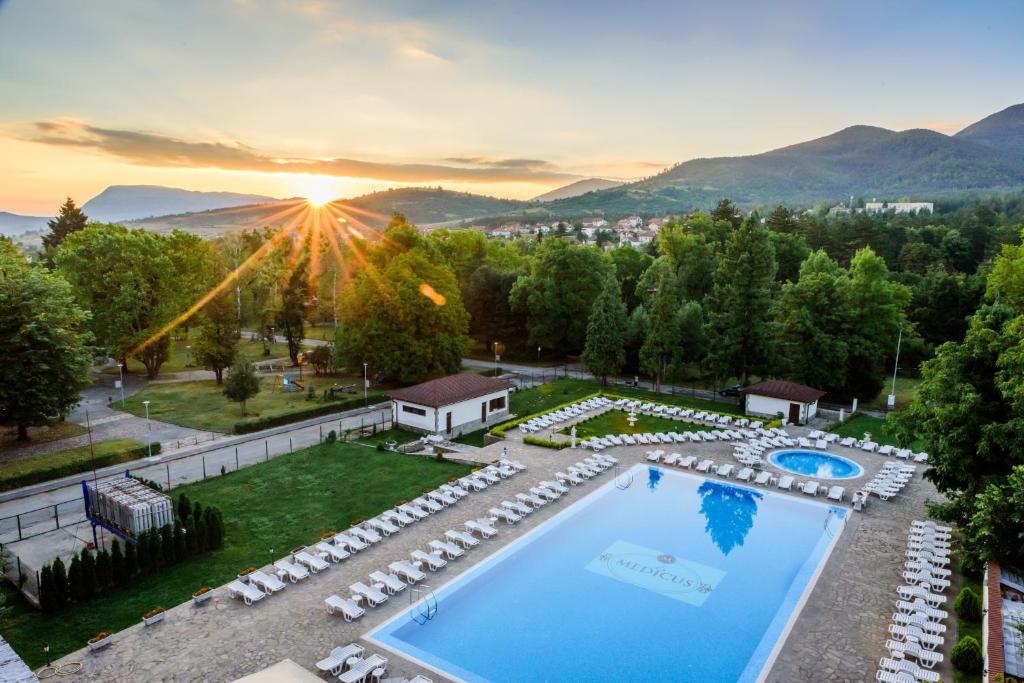 沃尔舍茨SPA Hotel Medicus的享有带游泳池的度假村的空中景致和日落美景