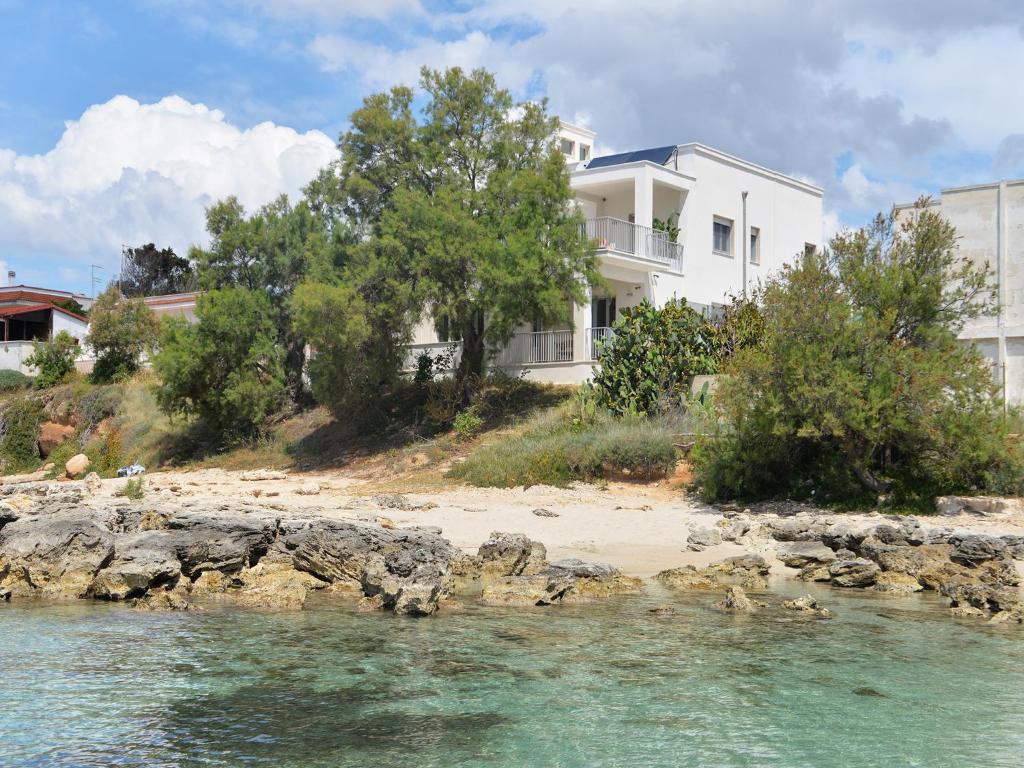 普尔萨诺Luxury Beach Villa Puglia Italy的海边的白色房子