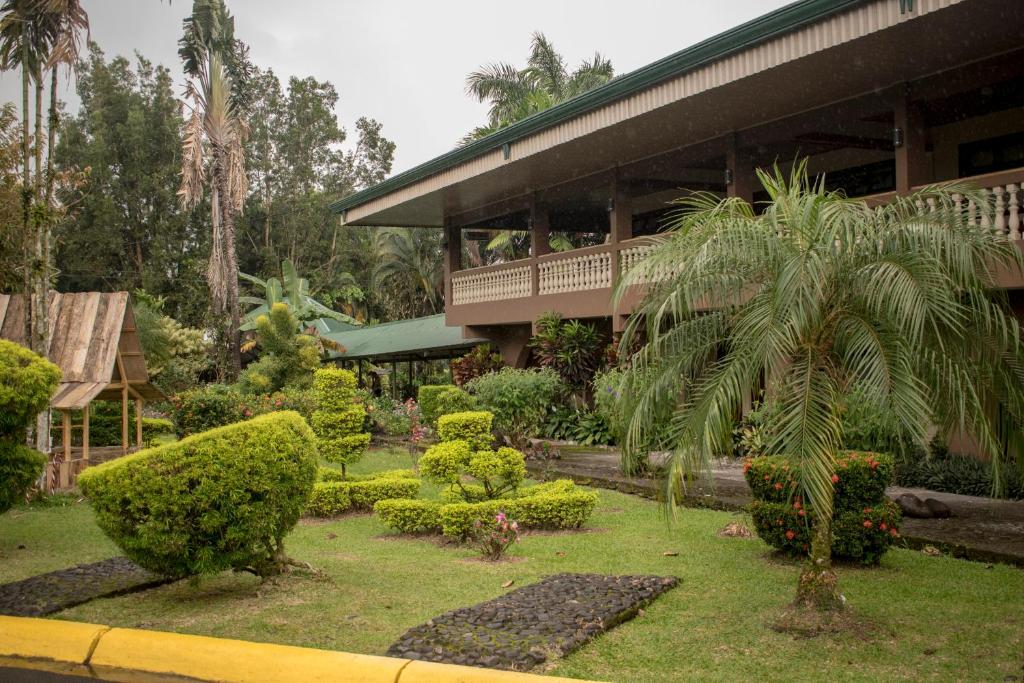 瓜皮莱斯Hotel Suerre的一座花园,在一座建筑前种有棕榈树