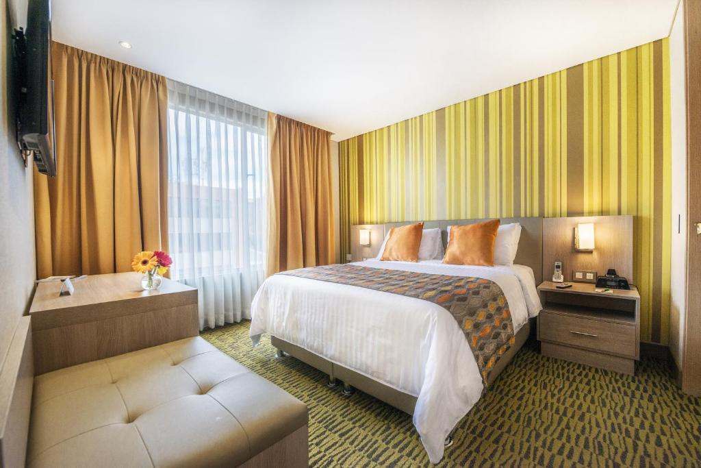 波哥大Apartamentos Plaza Suites的酒店客房设有一张床和一个大窗户